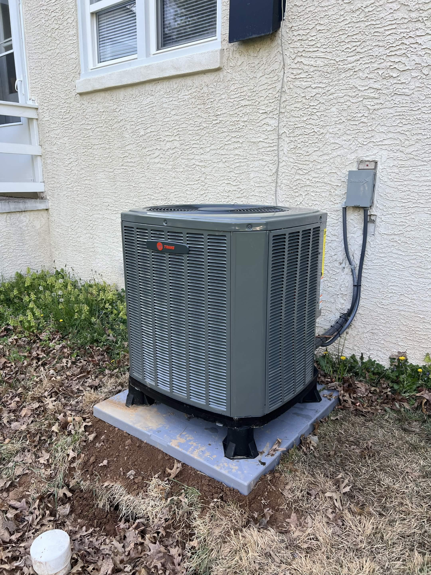 Outdoor condenser installation completed by C&S Heating & Cooling beside a home.